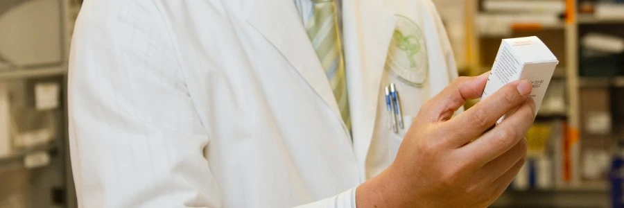 A male pharmacist is examining a drug in a pharmacy